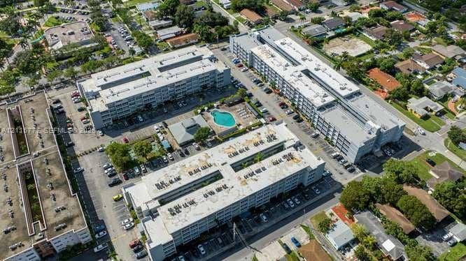 215 SE 3rd Avenue, #501B, Hallandale Beach, FL 33009 Aerial view of a residential complex featuring multiple multi-story buildings, a centralized outdoor swimming pool, and designated on-site surface parking