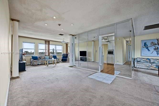 215 SE 3rd Avenue, #501B, Hallandale Beach, FL 33009 Spacious interior featuring mirrored floor-to-ceiling wall panels, decorative support columns, and multiple windows