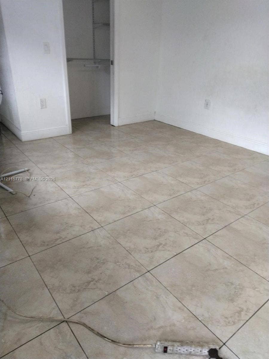 Neutral-toned tile flooring and a built-in reach-in closet