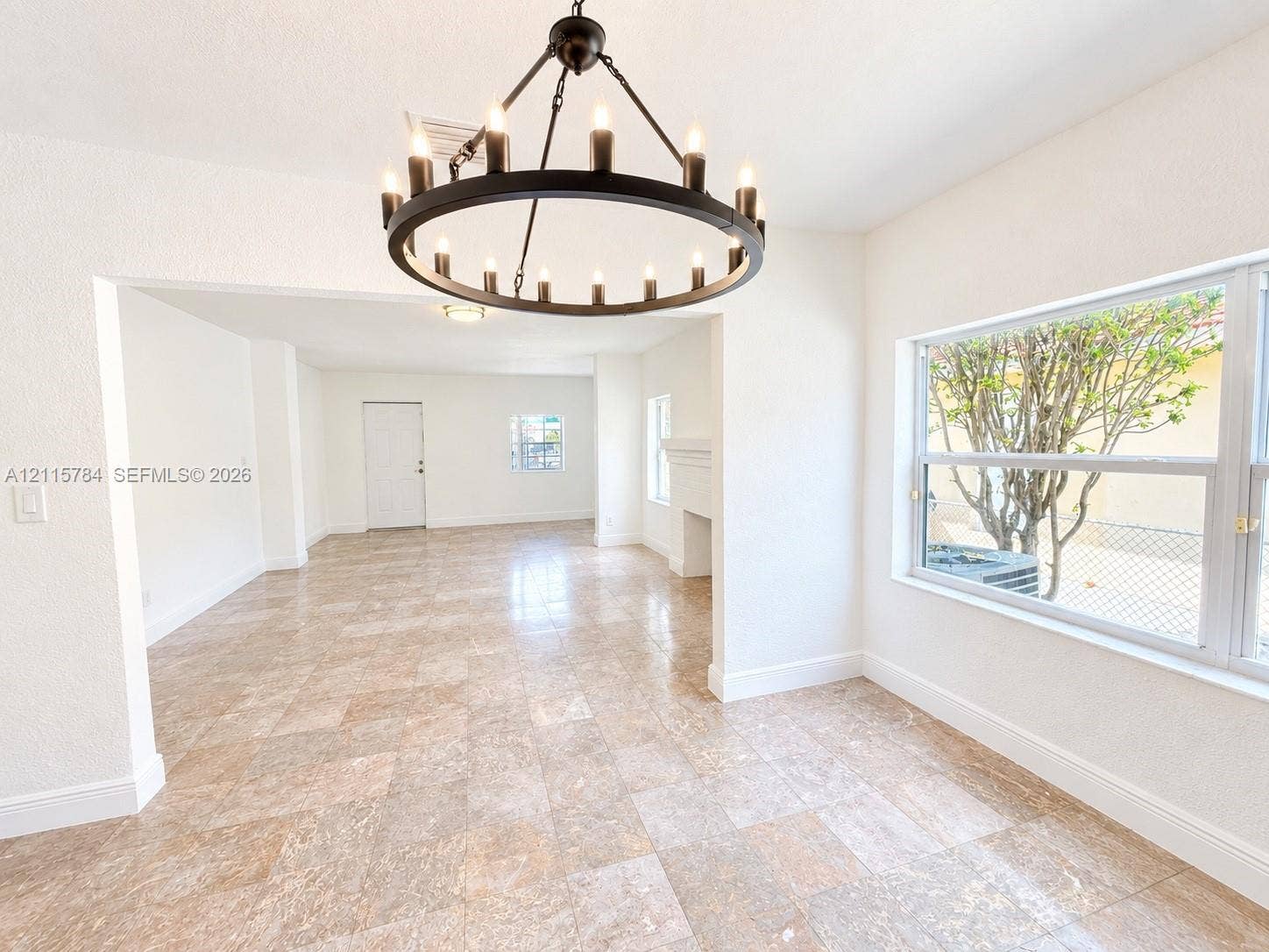 3655 SW 24th Terrace, #1, Miami, Miami, FL 33145 Interior space featuring large-format tile flooring, a circular multi-light chandelier, and a masonry fireplace mantel