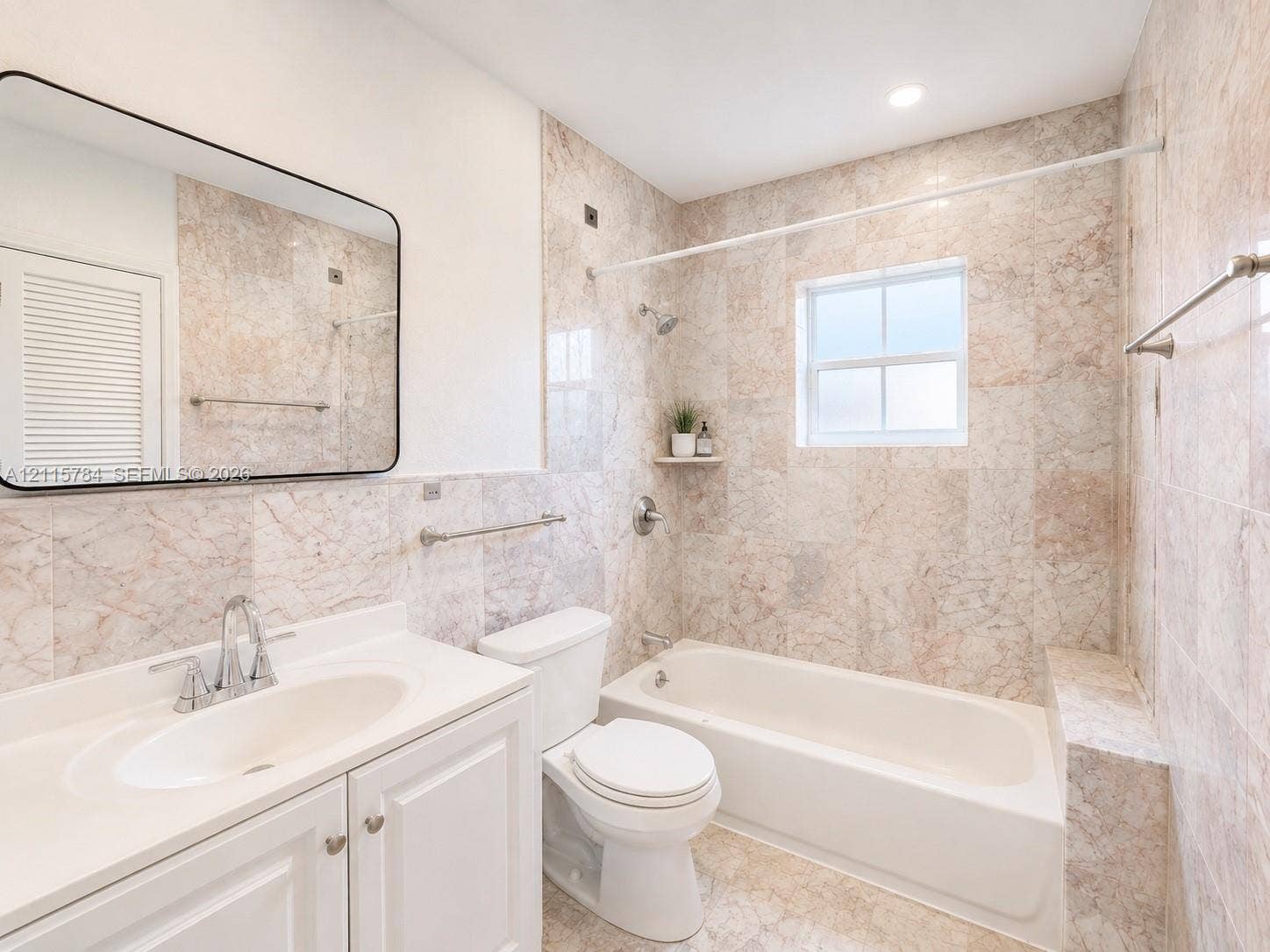 3655 SW 24th Terrace, #1, Miami, Miami, FL 33145 Bathroom featuring full-height stone wall tiling, a built-in bathtub with a shower head, vanity with a white countertop and integrated sink, framed mirror, and a window