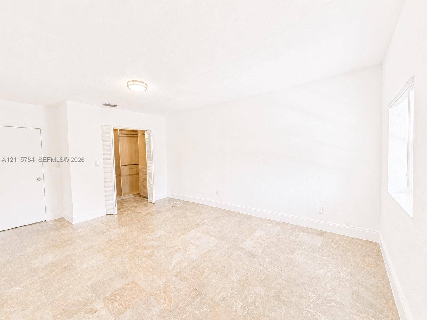 3655 SW 24th Terrace, #1, Miami, Miami, FL 33145 Bright interior space featuring polished tile flooring, neutral wall finishes, a window with natural light, and a built-in closet with shelving