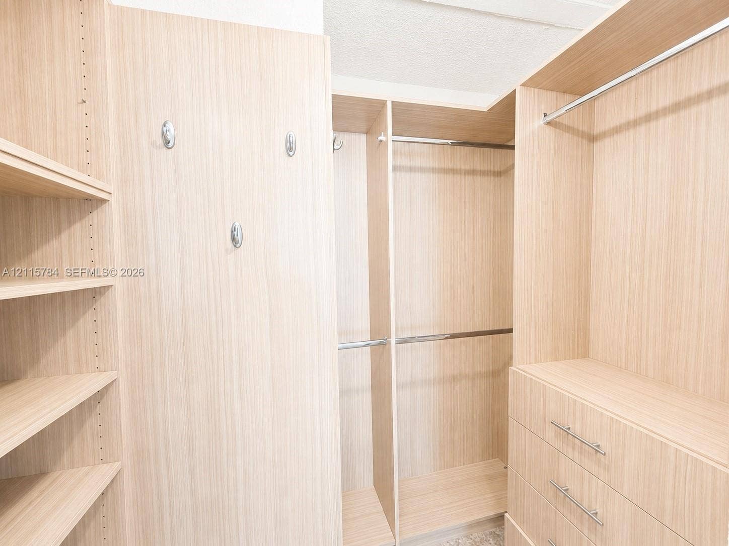 3655 SW 24th Terrace, #1, Miami, Miami, FL 33145 Custom reach-in closet featuring light-toned wood-finish cabinetry, built-in shelving, integrated hanging rods, three-drawer storage unit, and polished metal hardware