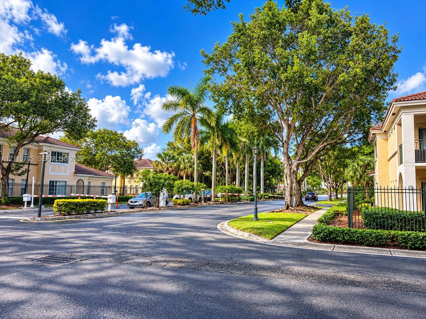 2494 Centergate Drive, #202, Miramar, Miramar, FL 33025 Community grounds featuring paved roadways, mature trees, manicured hedges, and decorative metal fencing