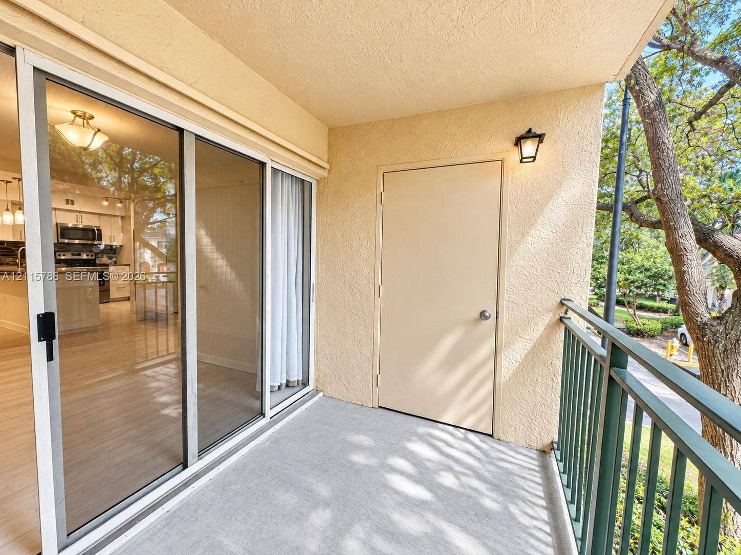 2494 Centergate Drive, #202, Miramar, Miramar, FL 33025 Covered balcony featuring concrete flooring, sliding glass door entry, metal railing, and an exterior storage closet