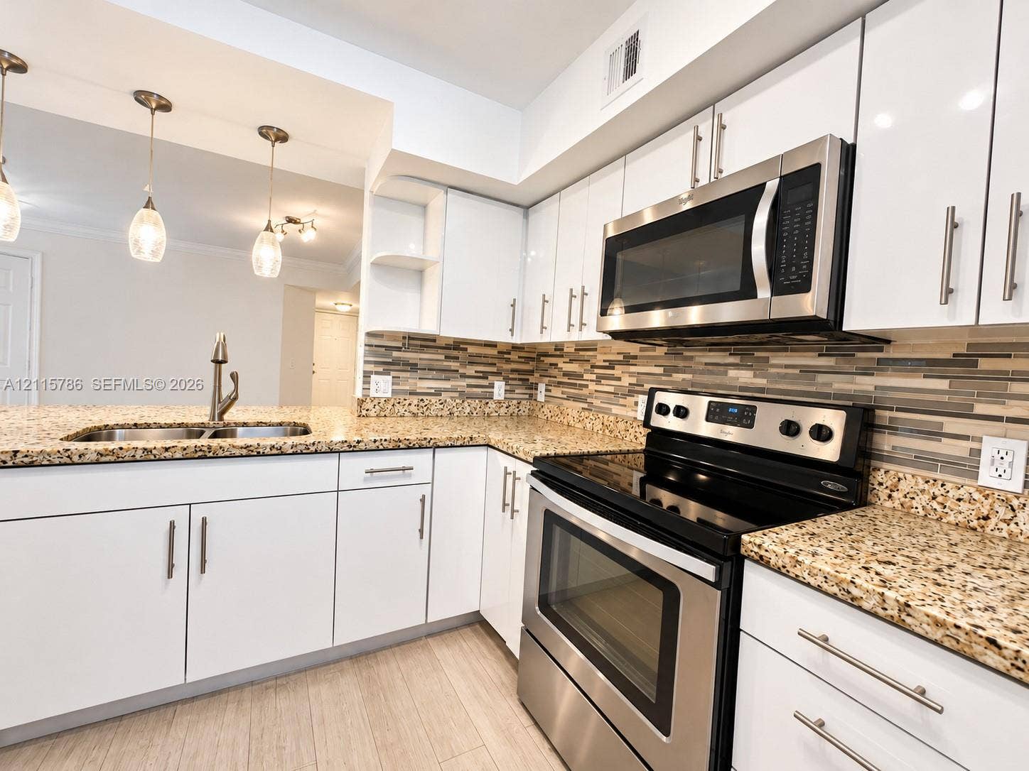 2494 Centergate Drive, #202, Miramar, Miramar, FL 33025 Kitchen featuring white cabinetry, stone-finish countertops, stainless steel appliances, a multi-tone tile backsplash, and overhead pendant lighting