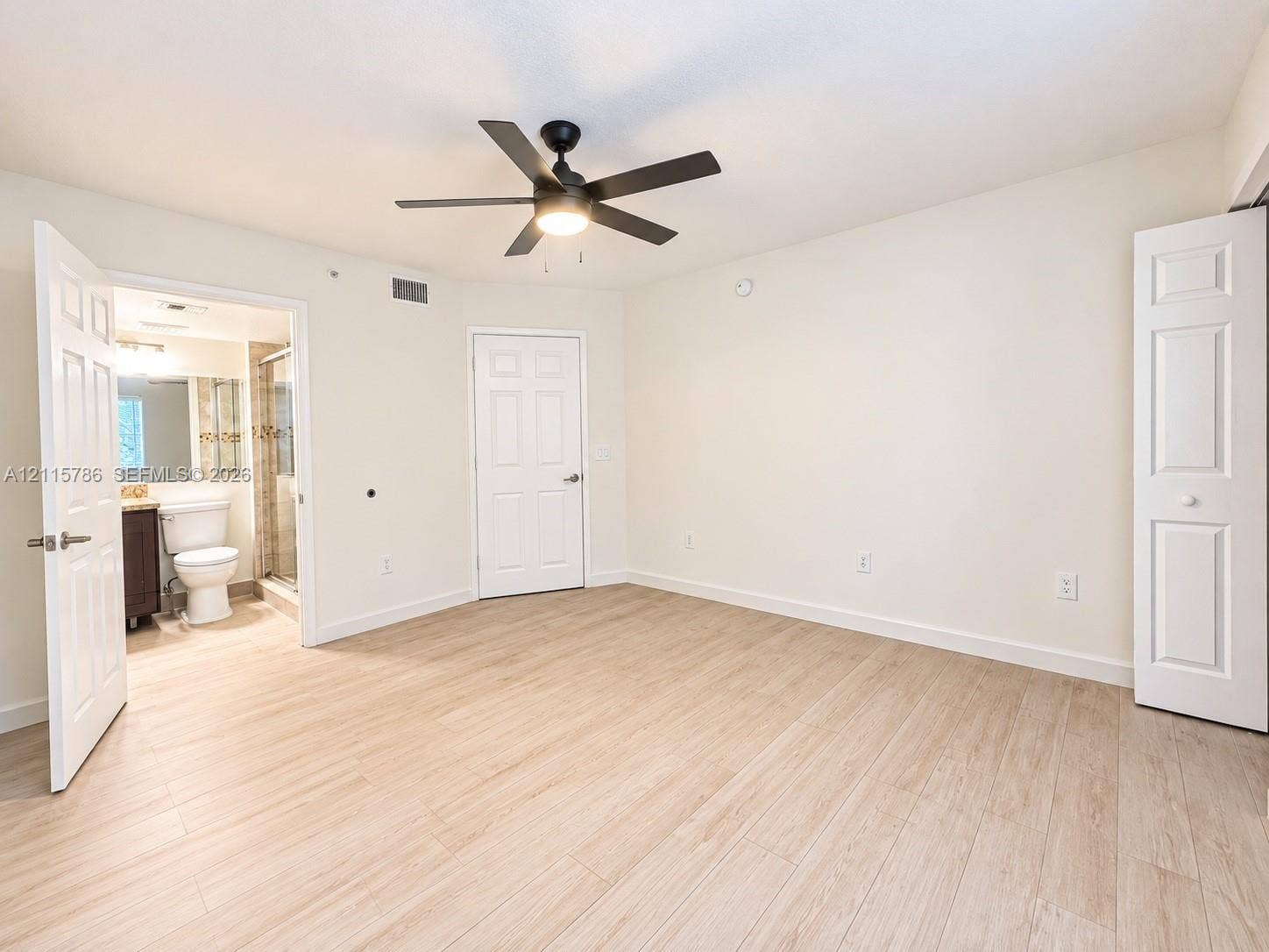 2494 Centergate Drive, #202, Miramar, Miramar, FL 33025 Room featuring wood-finish flooring, a central ceiling fan with integrated lighting, and white six-panel interior doors