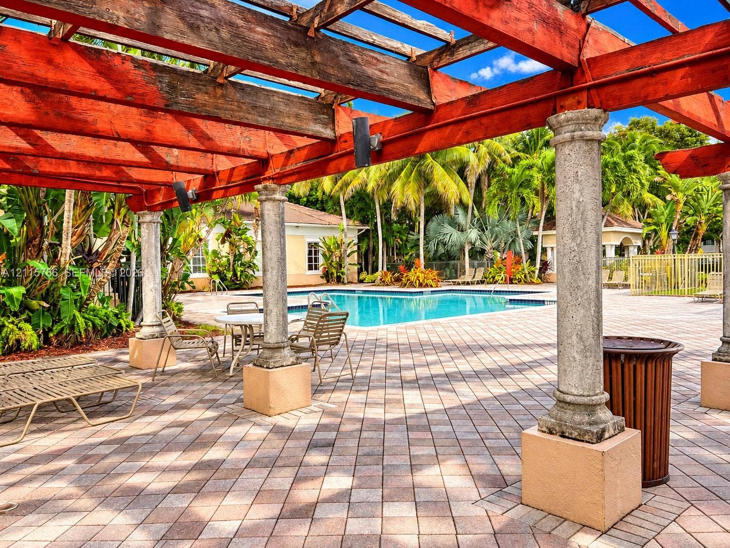 2494 Centergate Drive, #202, Miramar, Miramar, FL 33025 Outdoor space featuring a timber-frame pergola supported by stone-finished columns, paver patio, and swimming pool