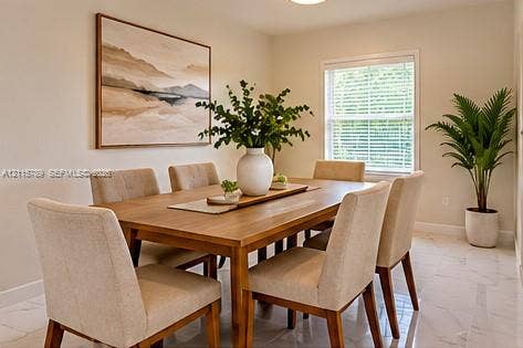 16220 NW 28th Place, Miami Gardens, FL 33054 Neutral-toned interior space featuring light-colored stone-finish flooring, a single window with horizontal blinds, and smooth-finished walls