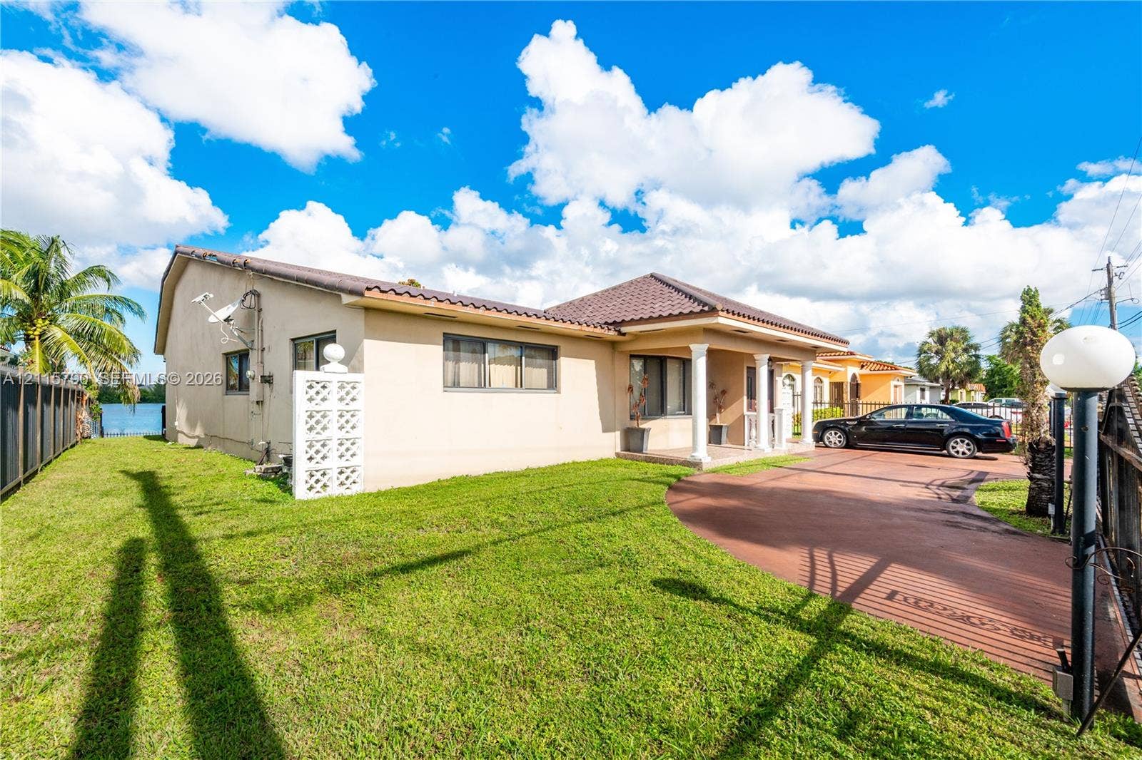 9120 NW 12th Avenue, Miami, FL 33150 Single-story exterior featuring a tile roof, stucco siding, a covered entryway with columns, and a paved driveway