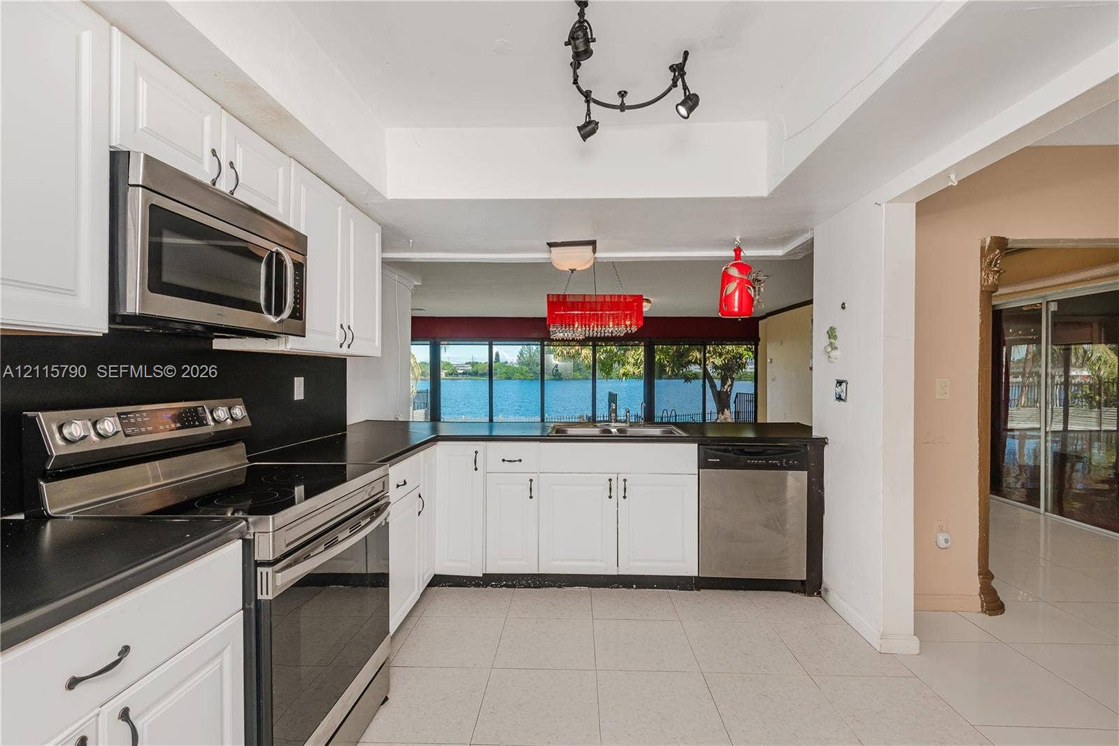 9120 NW 12th Avenue, Miami, FL 33150 Kitchen featuring white cabinetry, stainless steel appliances, solid-surface countertops, tile flooring, and track lighting