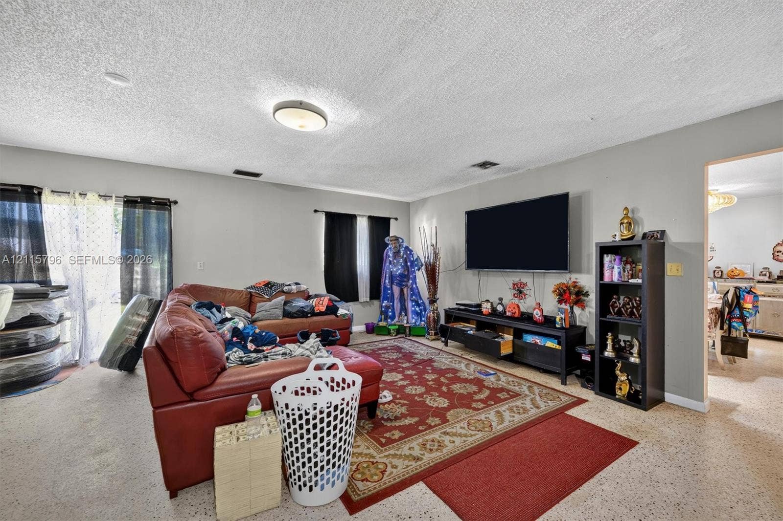 Living area featuring neutral-toned walls, terrazzo flooring, and a flush-mount ceiling light fixture