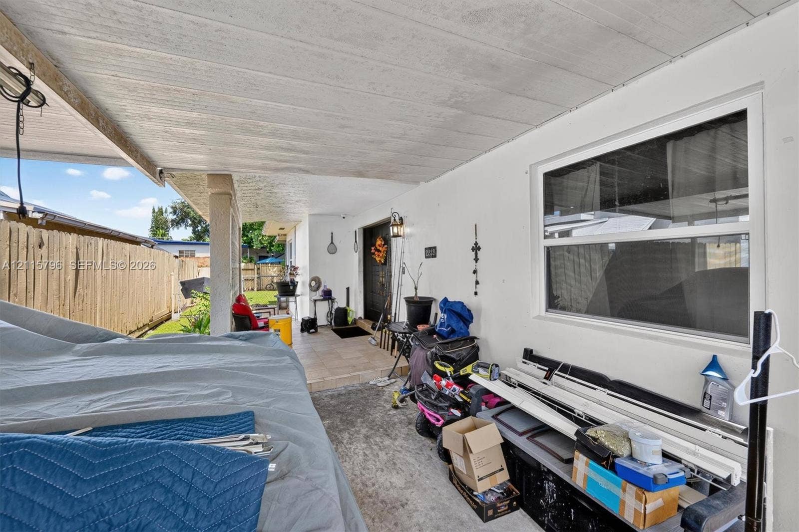 Covered patio area with a concrete floor, painted exterior walls, and a large horizontal window