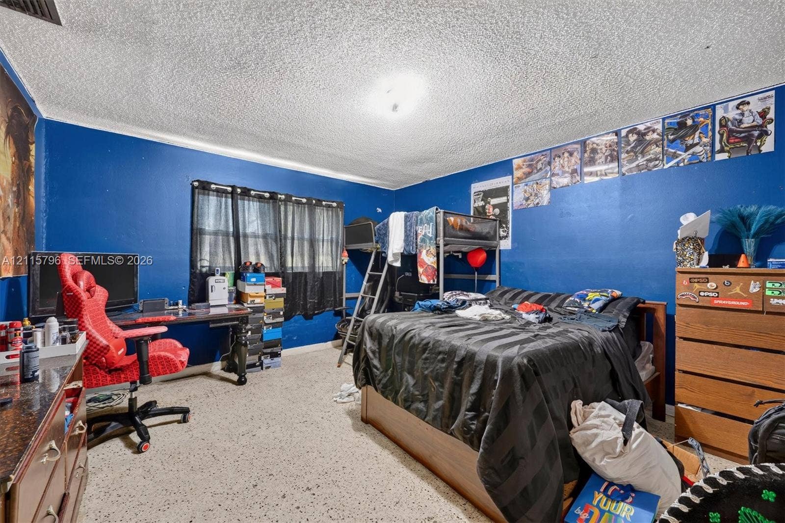 Spacious room featuring neutral speckled flooring and a ceiling light fixture