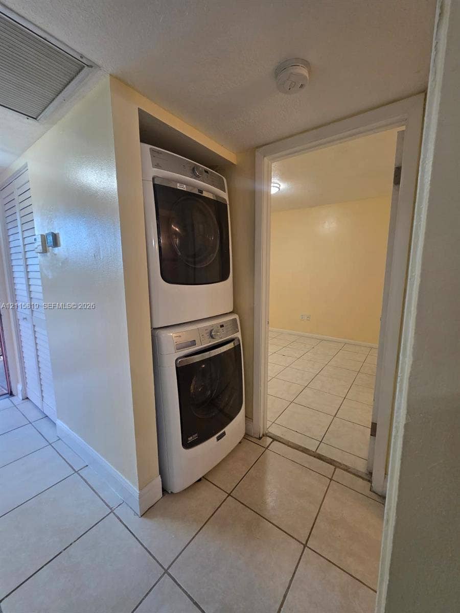 831 NE 207th Lane, #2-203, Miami, Miami, FL 33179 Stacked white front-load washer and dryer unit with ceramic tile flooring