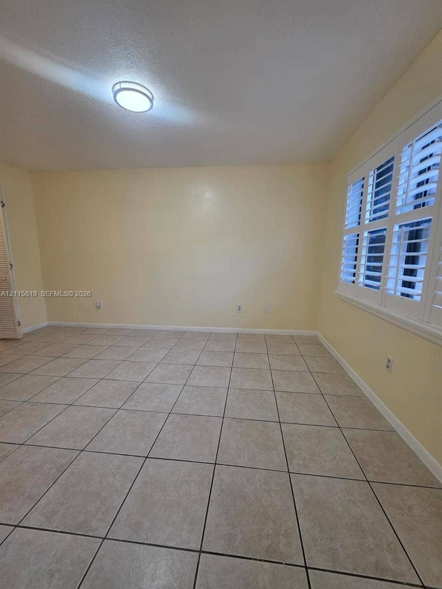 831 NE 207th Lane, #2-203, Miami, Miami, FL 33179 Neutral-toned ceramic tile flooring, plantation shutters, and flush-mount overhead lighting