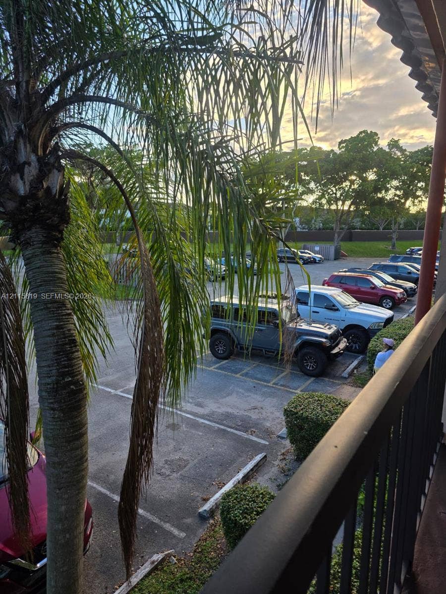 831 NE 207th Lane, #2-203, Miami, Miami, FL 33179 Private balcony featuring dark metal railings and mature palm foliage