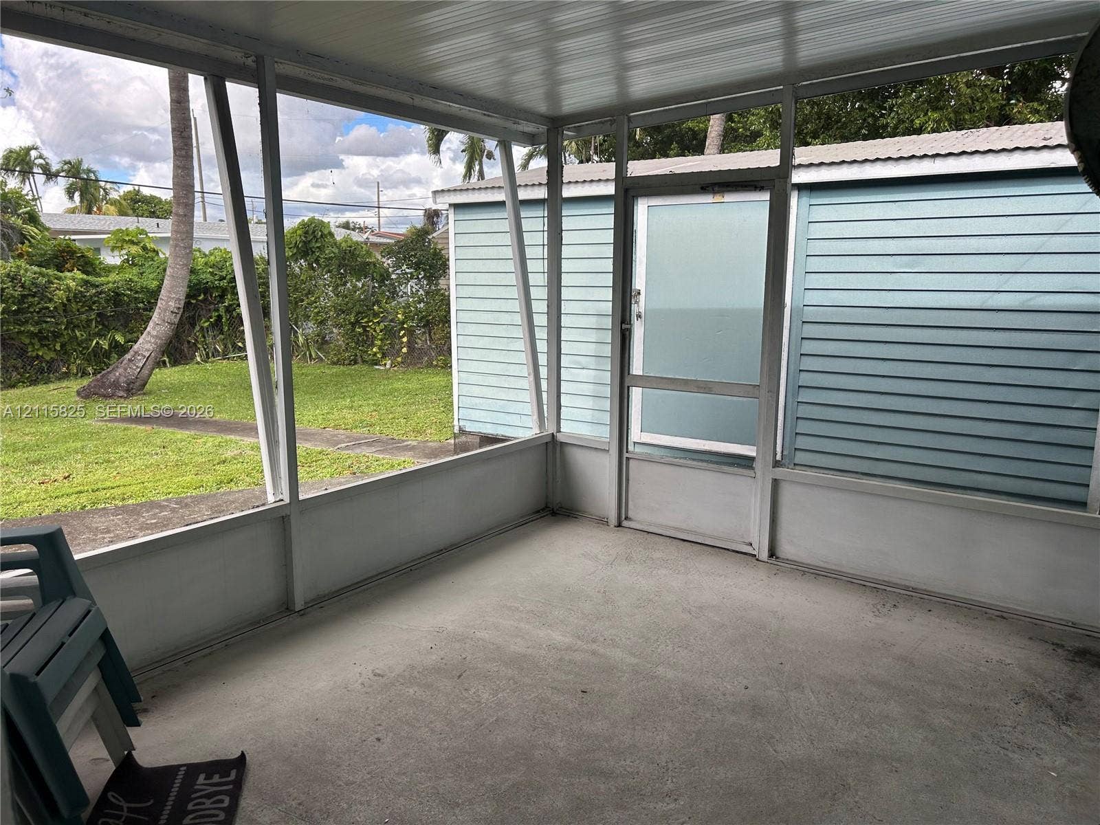 7130 W 12th Court, Hialeah, FL 33014 Screened-in enclosure featuring a concrete floor, metal framing, and a dedicated screen door