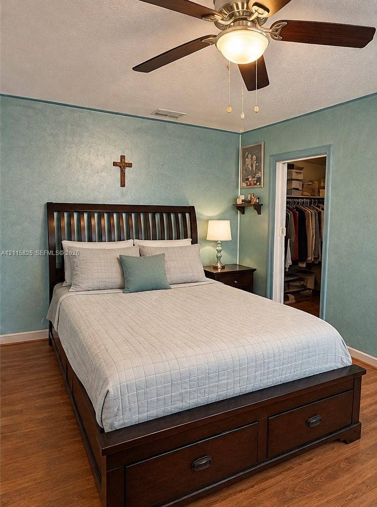 7130 W 12th Court, Hialeah, FL 33014 Room featuring wood-finish flooring, textured wall finish, and a ceiling fan with integrated lighting