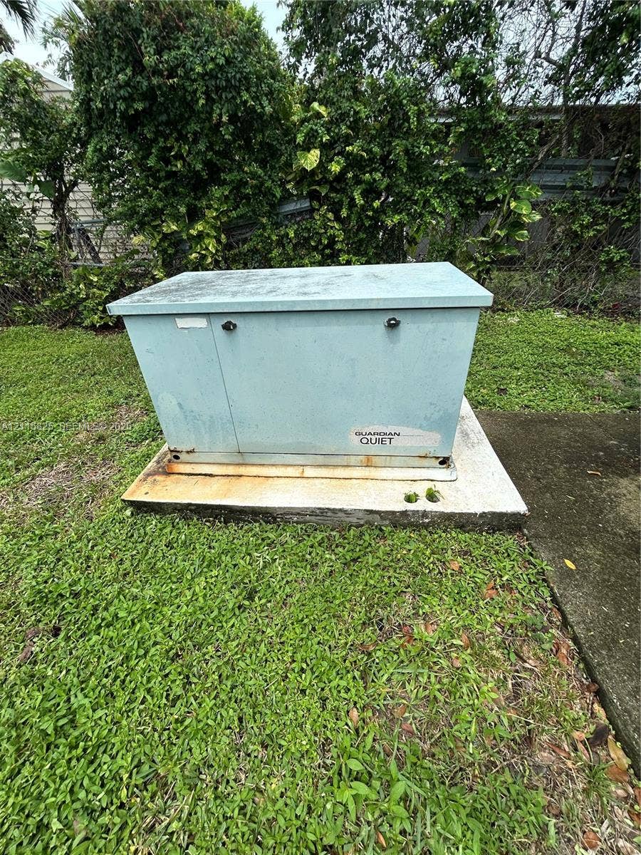 7130 W 12th Court, Hialeah, FL 33014 Standby generator housed in a protective metal enclosure on a concrete pad