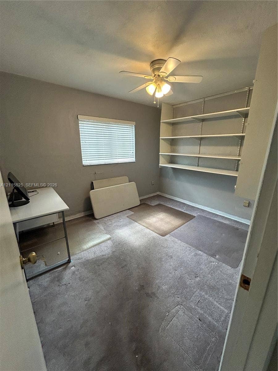 7130 W 12th Court, Hialeah, FL 33014 Room featuring wall-mounted shelving and a ceiling-mounted light fixture with fan