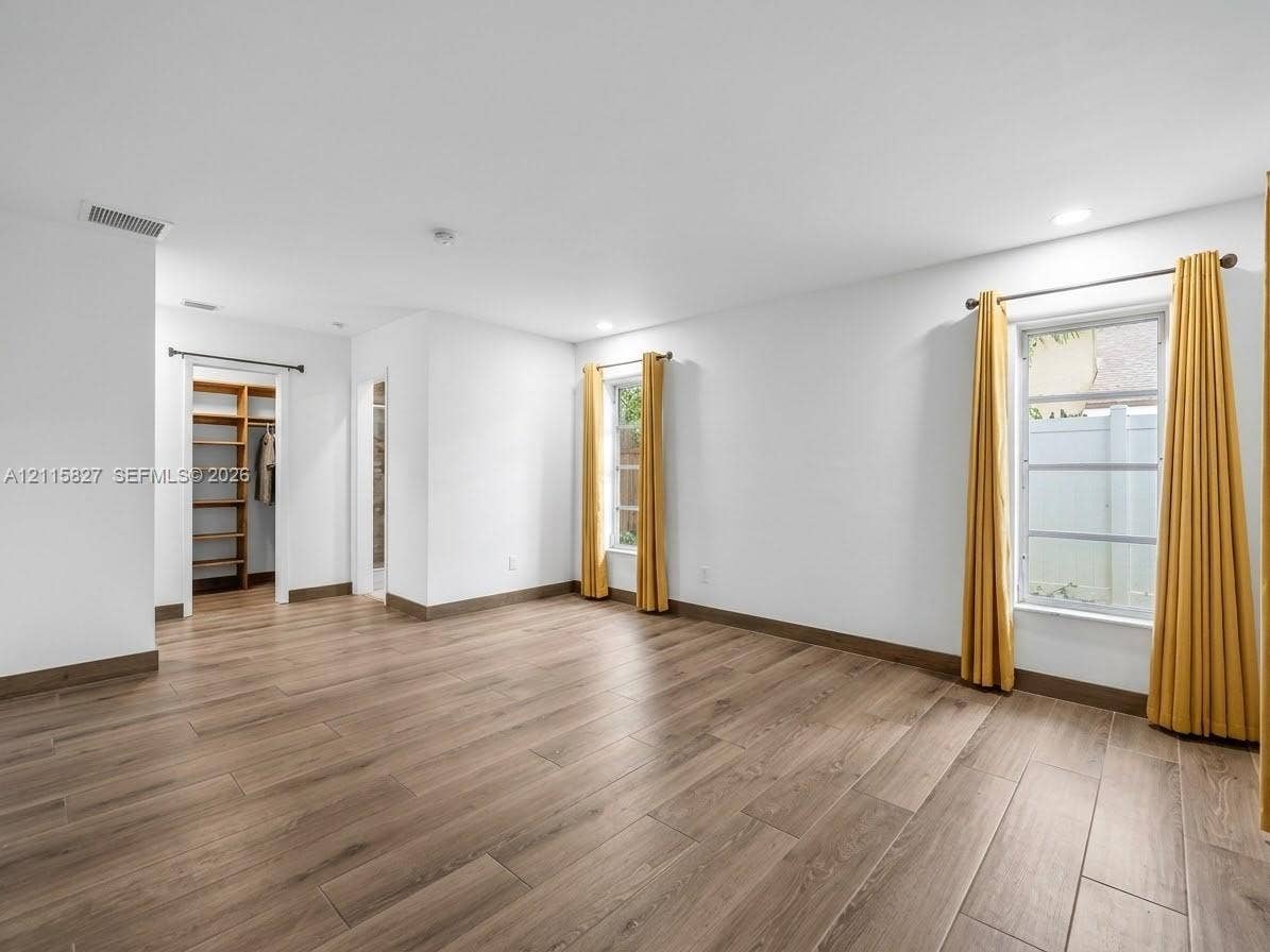 411 Wilma Circle, #0, Riviera Beach, Riviera Beach, FL 33404 Room interior featuring wood-finish flooring, recessed lighting, and a walk-in closet with built-in wooden shelving