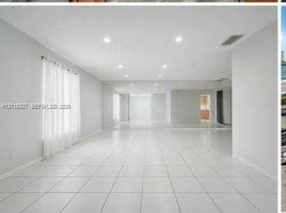 411 Wilma Circle, #0, Riviera Beach, Riviera Beach, FL 33404 Open-concept room featuring white tile flooring, recessed ceiling lighting, and a full-length mirrored wall