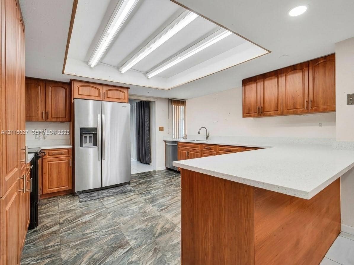 411 Wilma Circle, #0, Riviera Beach, Riviera Beach, FL 33404 Kitchen featuring wood cabinetry, stone-finish countertops, stainless steel side-by-side refrigerator, recessed lighting, and patterned tile flooring
