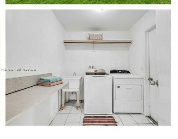 411 Wilma Circle, #0, Riviera Beach, Riviera Beach, FL 33404 Laundry space featuring ceramic tile flooring, a utility sink with a faucet, a solid-surface folding counter, and a built-in wall-mounted shelf with a hanging rod