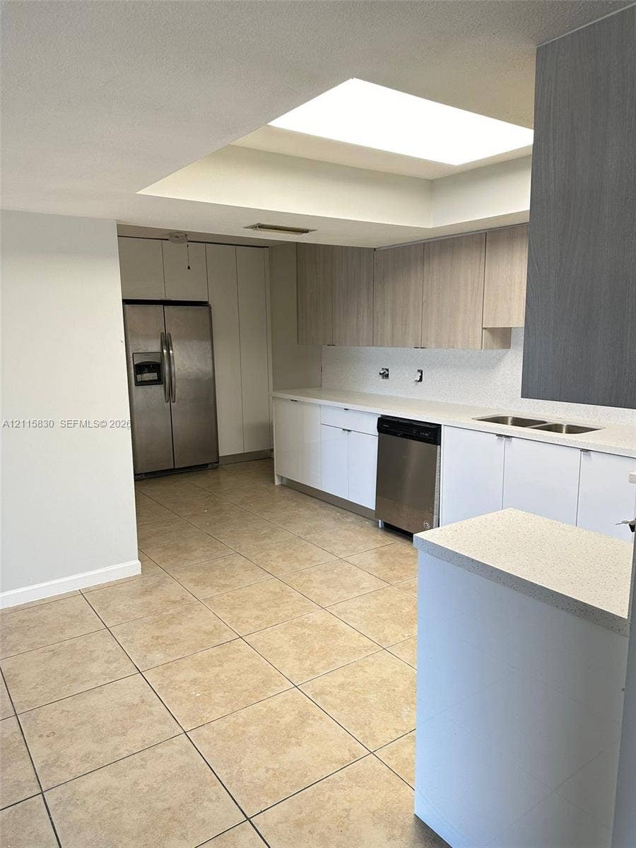 9061 NW 25th Court, #0, Sunrise, Sunrise, FL 33322 Kitchen featuring tile flooring, skylight, quartz countertops, dual-toned cabinetry, and stainless steel appliances