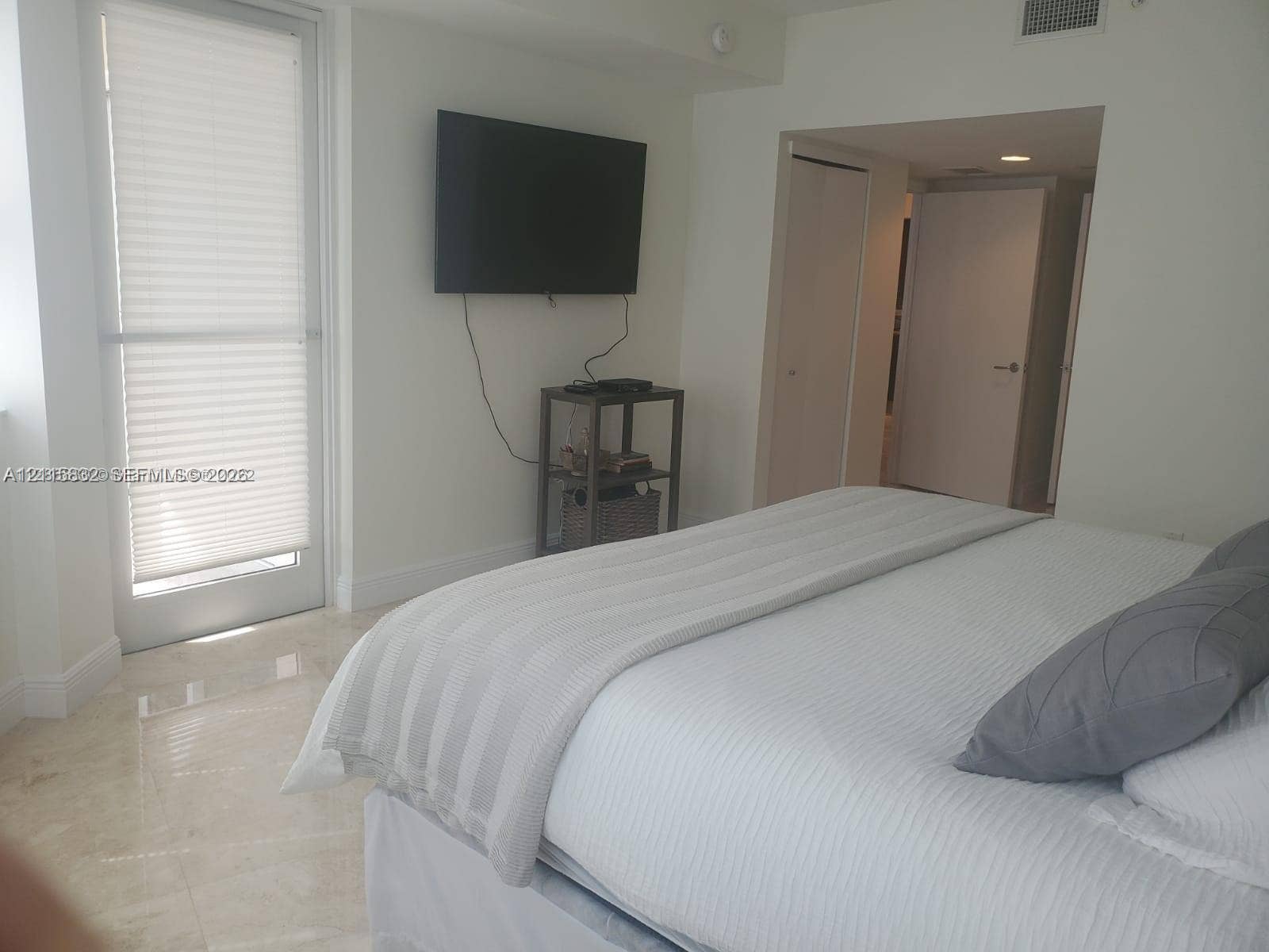 19900 E Country Club Drive, #607, Aventura, Aventura, FL 33180 Polished stone flooring, floor-to-ceiling glass door with integrated blinds, and multiple built-in closets