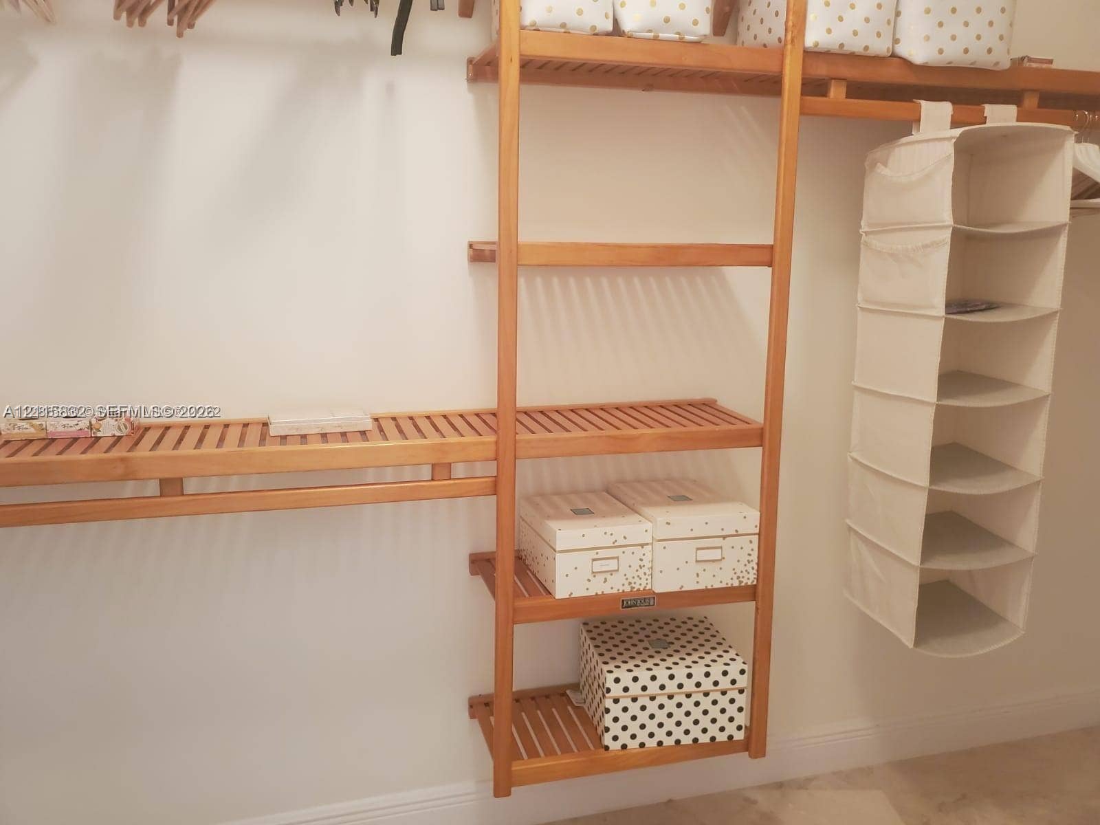 19900 E Country Club Drive, #607, Aventura, Aventura, FL 33180 Custom-built wood shelving featuring multi-tiered vertical towers and slatted horizontal racks with integrated hanging rods