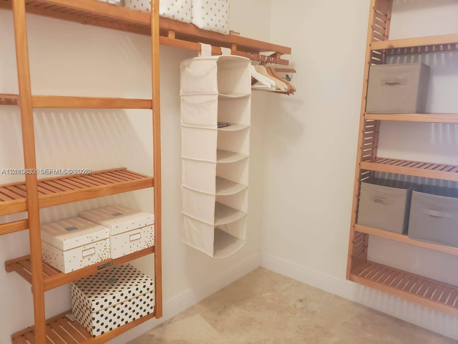 19900 E Country Club Drive, #607, Aventura, Aventura, FL 33180 Walk-in closet featuring multi-level wooden shelving and wall-to-wall stone-finish flooring