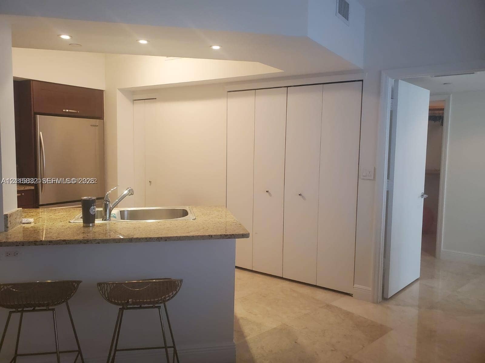 19900 E Country Club Drive, #607, Aventura, Aventura, FL 33180 Kitchen featuring a stone-surface breakfast bar, stainless steel refrigerator, recessed lighting, and white bi-fold closet doors