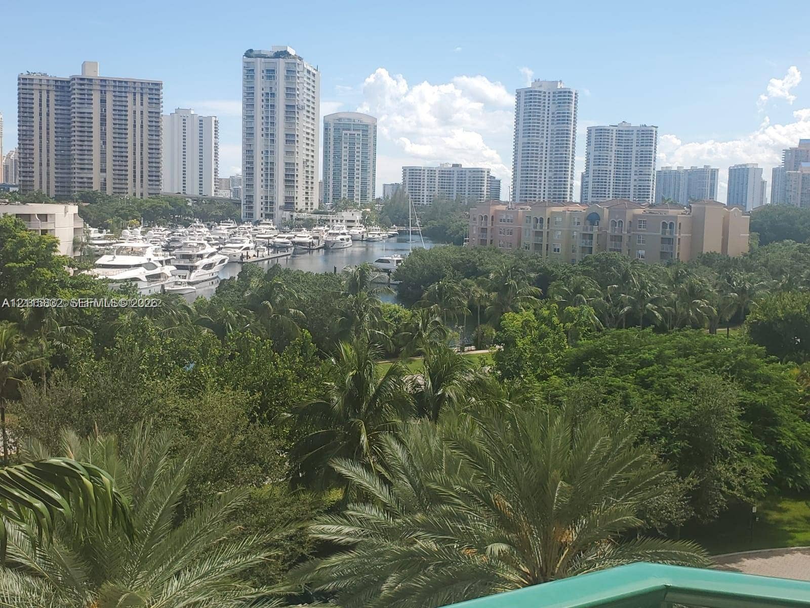 19900 E Country Club Drive, #607, Aventura, Aventura, FL 33180 Panoramic scenery featuring mature palm trees, a winding waterway, a moored marina, and urban skyline high-rises
