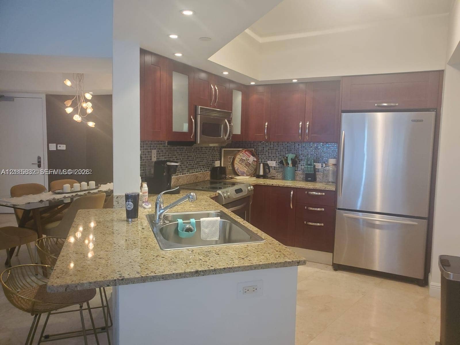 19900 E Country Club Drive, #607, Aventura, Aventura, FL 33180 Kitchen featuring wooden cabinetry, stone-finish countertops, stainless steel appliances, recessed ceiling lighting, and a mosaic tile backsplash