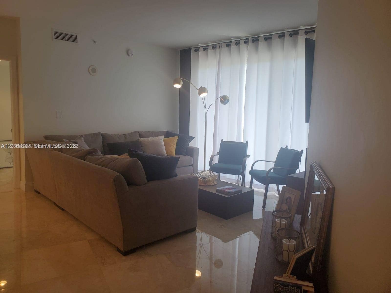 19900 E Country Club Drive, #607, Aventura, Aventura, FL 33180 Polished stone flooring and large sliding glass doors with floor-to-ceiling curtain panels