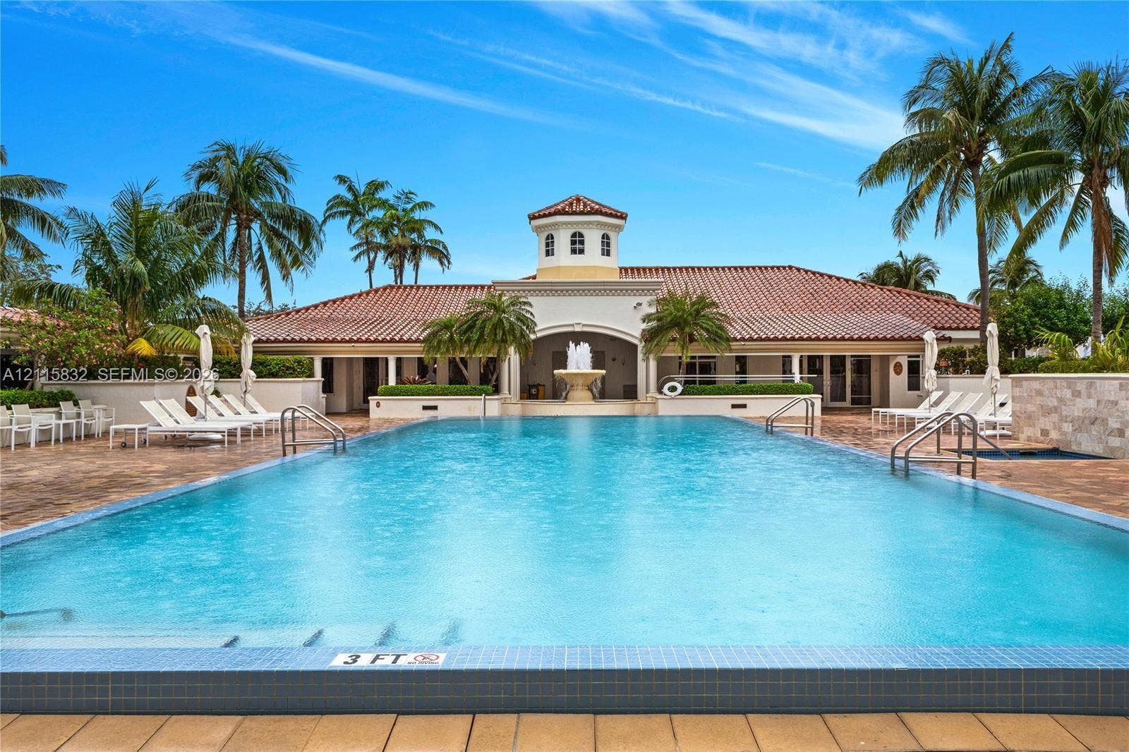 19900 E Country Club Drive, #607, Aventura, Aventura, FL 33180 In-ground swimming pool with tile trim, decorative central fountain, tile-paved patio, and stucco exterior with a tiled roof