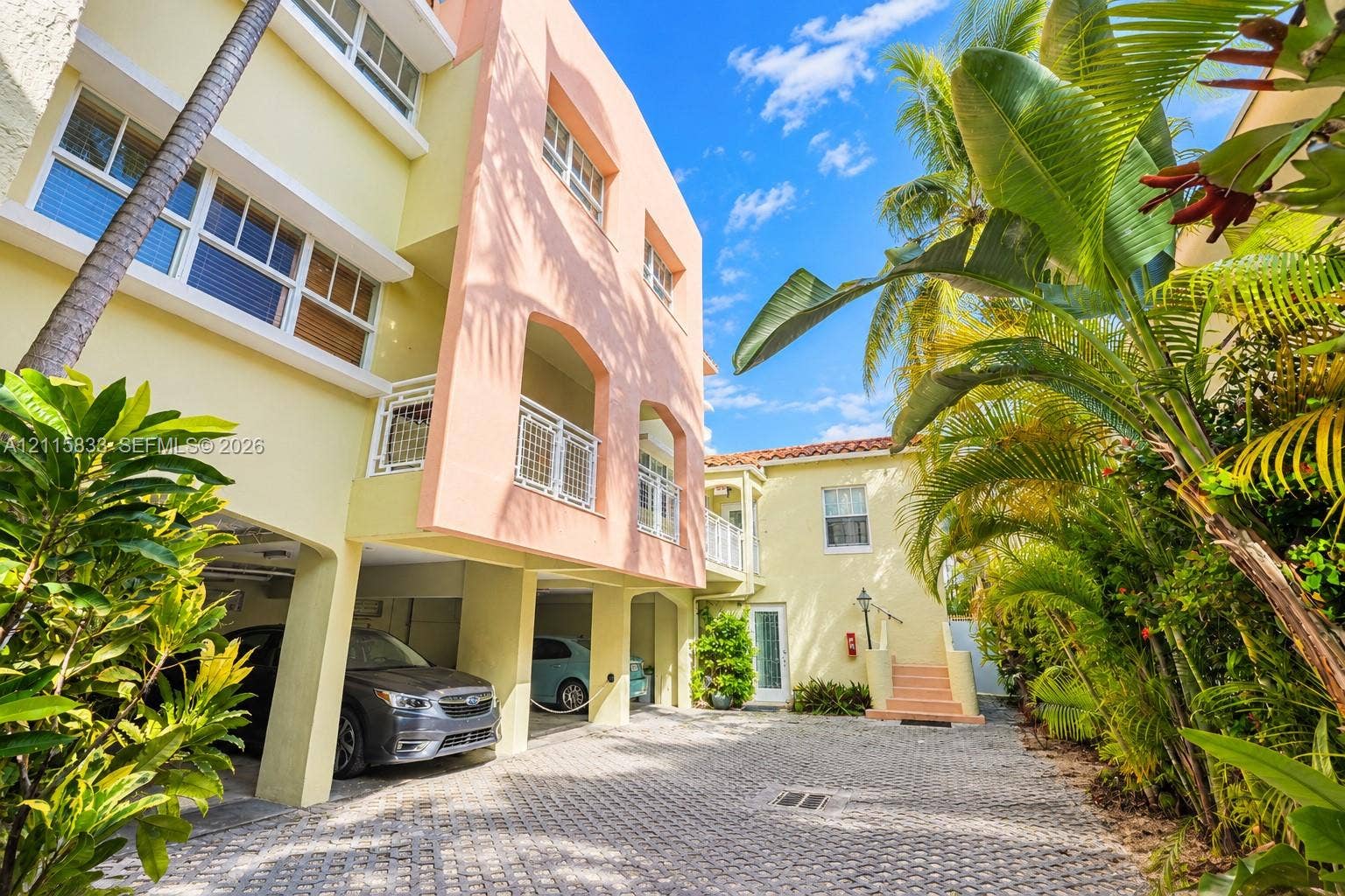 929 Meridian Avenue, #5, Miami Beach, FL 33139 Stucco exterior featuring multi-level arched balconies, covered parking, and paved motor court