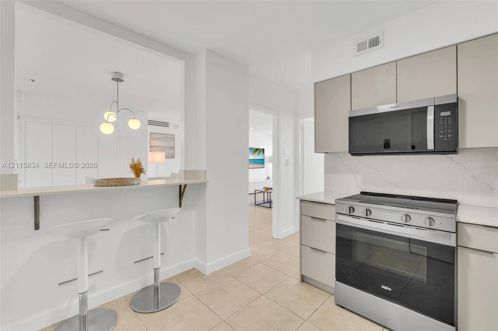 5161 Collins Avenue, #1717, Miami Beach, Miami Beach, FL 33140 Kitchen featuring flat-panel cabinetry, a quartz countertop with a matching backsplash, stainless steel appliances, and a breakfast bar