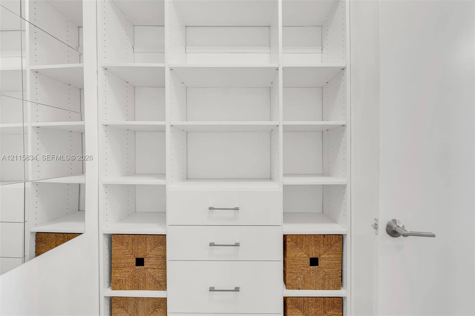 5161 Collins Avenue, #1717, Miami Beach, Miami Beach, FL 33140 Custom white built-in shelving featuring adjustable dividers, integrated drawers with metallic hardware, and a mirrored side panel