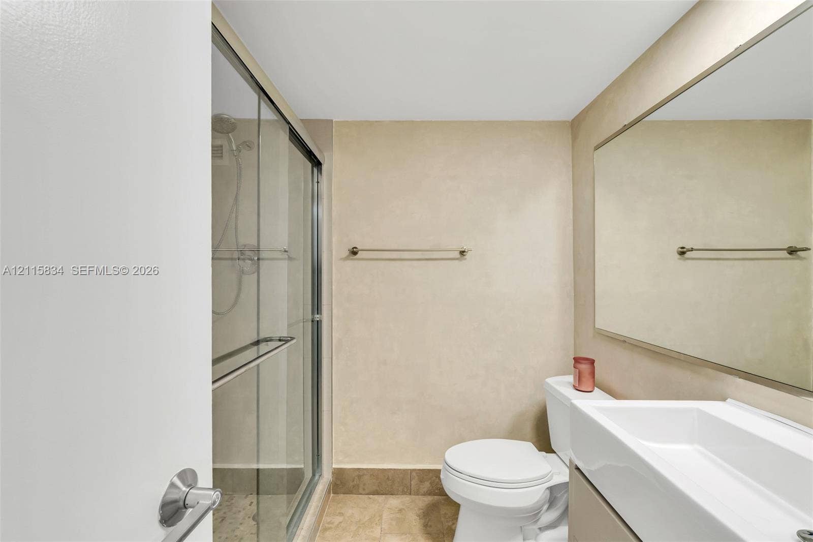 5161 Collins Avenue, #1717, Miami Beach, Miami Beach, FL 33140 Bathroom featuring a walk-in shower with a glass enclosure, a wall-mounted mirror, a rectangular vessel sink with a vanity, and a neutral-toned tile floor