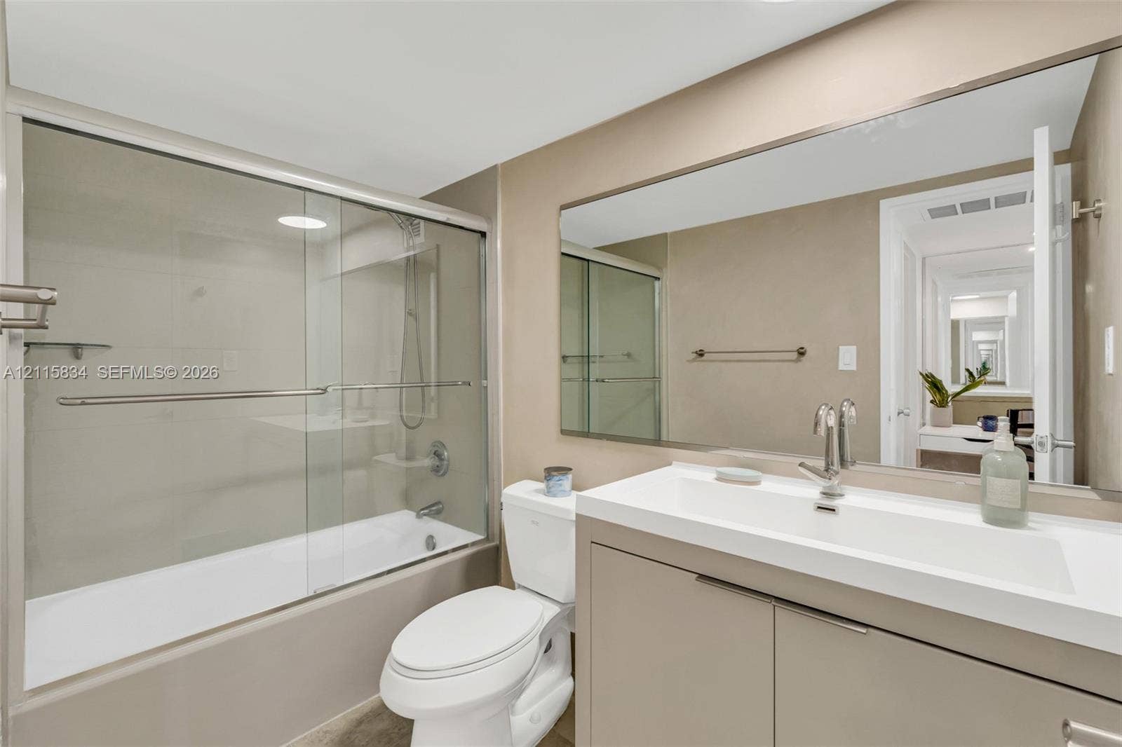 5161 Collins Avenue, #1717, Miami Beach, Miami Beach, FL 33140 Bathroom featuring a floating vanity with an integrated sink, large wall-mounted mirror, glass-enclosed shower and tub combination, and chrome fixtures