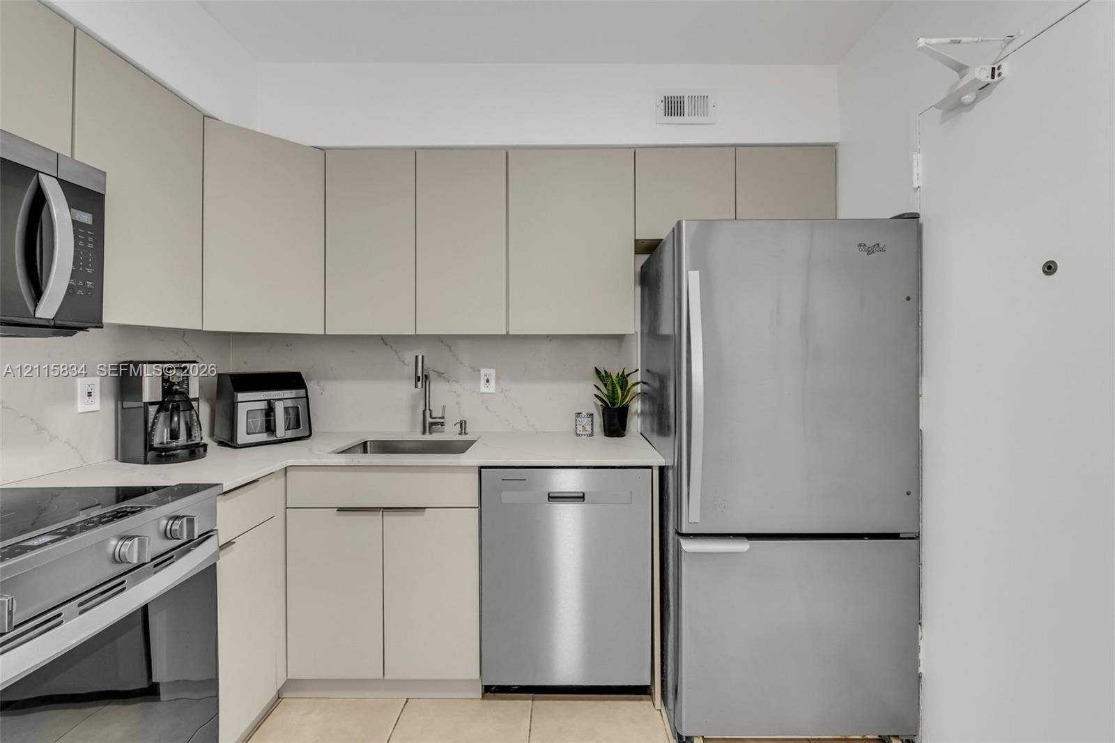 5161 Collins Avenue, #1717, Miami Beach, Miami Beach, FL 33140 Kitchen featuring flat-panel cabinetry, stainless steel appliances, light-toned countertops with a matching backsplash, and tile flooring