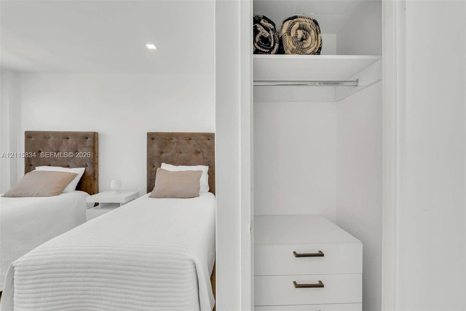 5161 Collins Avenue, #1717, Miami Beach, Miami Beach, FL 33140 Built-in closet featuring white cabinetry, two drawers with matte black hardware, an upper storage shelf, and a metal hanging rod