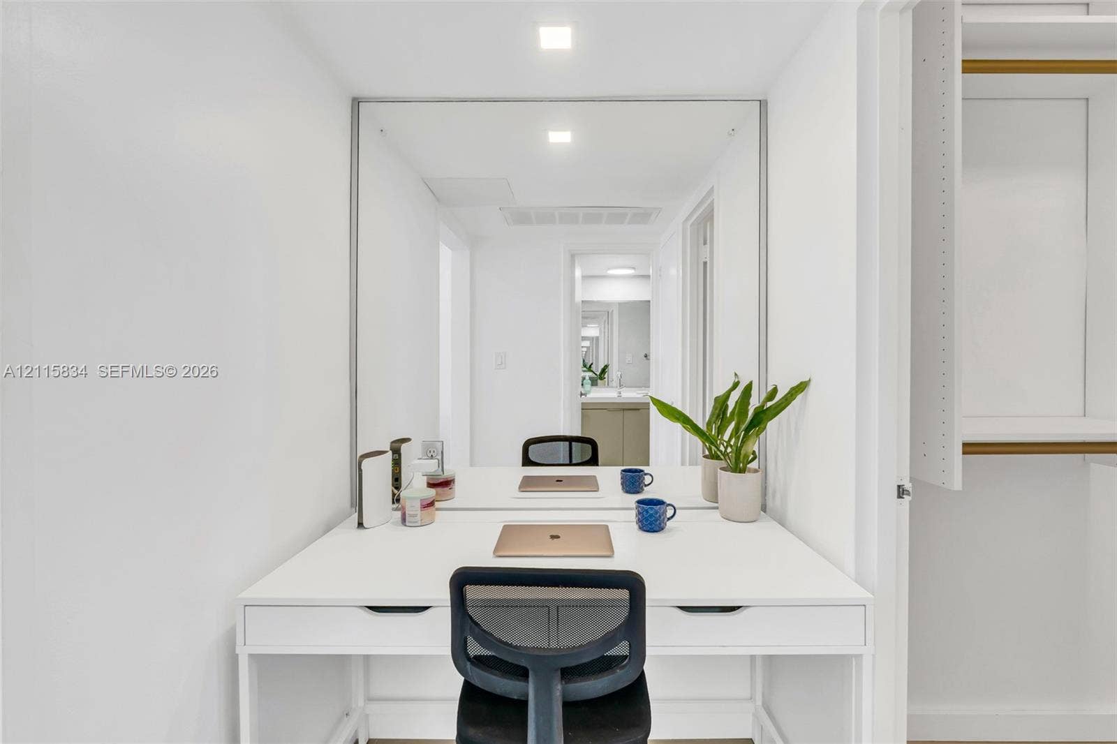5161 Collins Avenue, #1717, Miami Beach, Miami Beach, FL 33140 Built-in white desk with integrated dual drawers, expansive wall-mounted mirror, recessed LED lighting, and white shelving units