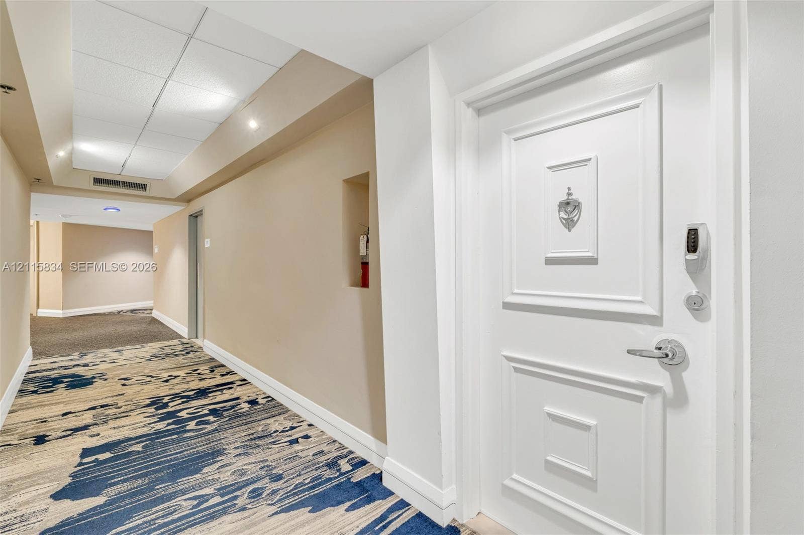 5161 Collins Avenue, #1717, Miami Beach, Miami Beach, FL 33140 Entryway featuring a white paneled door with a metallic door knocker and electronic keypad deadbolt lock, accented by a wall-recessed niche