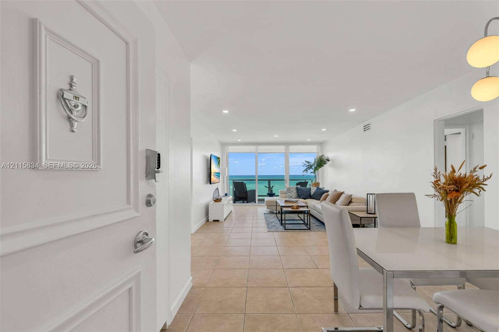 5161 Collins Avenue, #1717, Miami Beach, Miami Beach, FL 33140 Entryway featuring a decorative metal door knocker, large-format tile flooring, recessed ceiling lighting, a modern multi-pendant light fixture, and floor-to-ceiling glass paneling