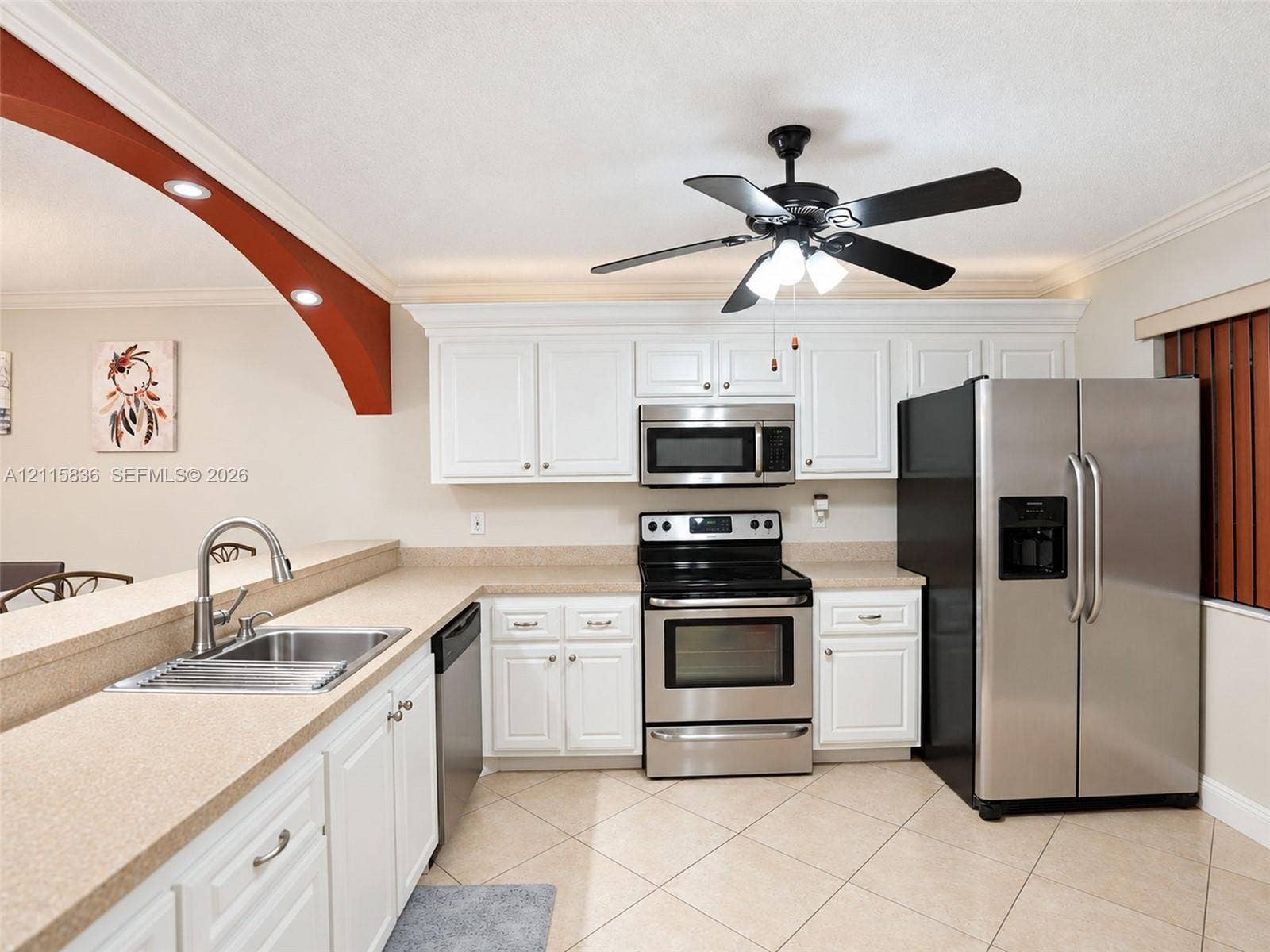 8000 Hampton Boulevard, #311, North Lauderdale, North Lauderdale, FL 33068 Kitchen featuring white cabinetry, solid-surface countertops, stainless steel appliances, a dual-basin sink with a pull-down faucet, and neutral tile flooring