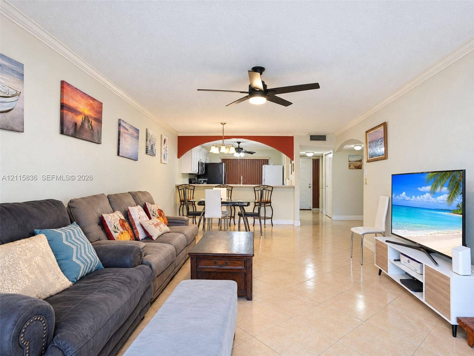 8000 Hampton Boulevard, #311, North Lauderdale, North Lauderdale, FL 33068 Open-concept living space featuring neutral ceramic tile flooring, a prominent decorative archway, recessed lighting, and a multi-blade ceiling fan